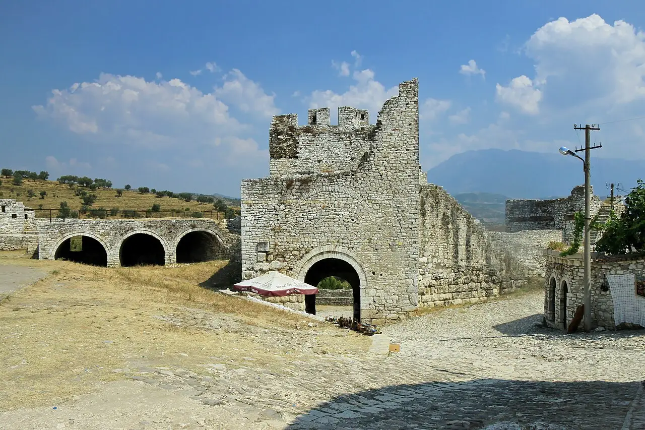 The stone walls and a gateway inside the Kala castle at Berat, with the valley and mountains beyond