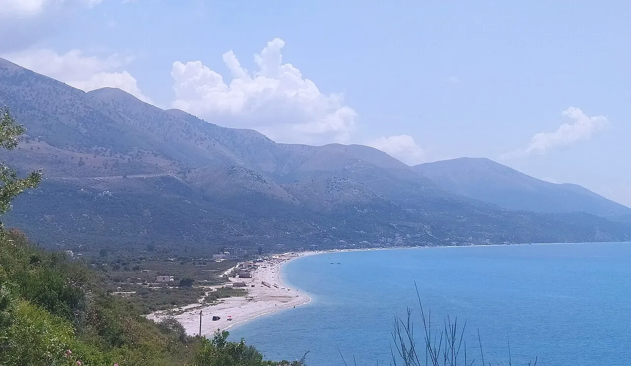 The long curving pebble beach of Borsh sweeping along the bay below the Ceraunian Mountains