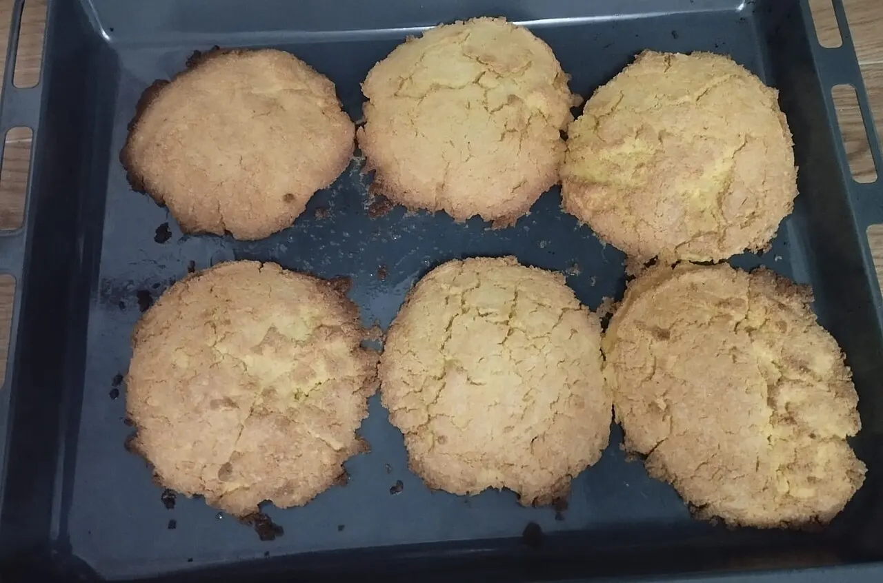 Six large golden ballokume cookies fresh from the oven in a black baking tray