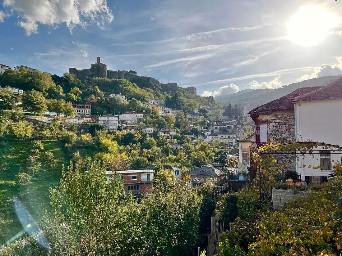 Stone houses and slate roofs of Gjirokastër cascading down a hillside above the Drino valley