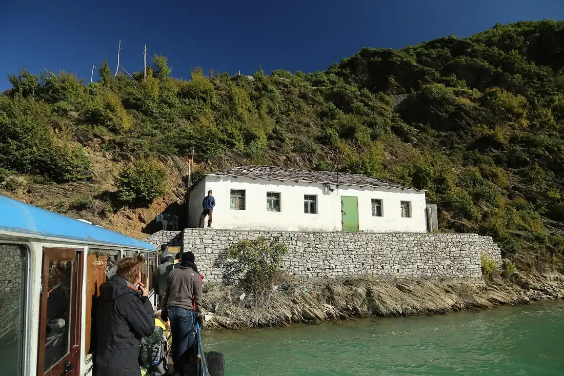 Passenger ferry crossing Lake Koman through steep wooded gorges in northern Albania