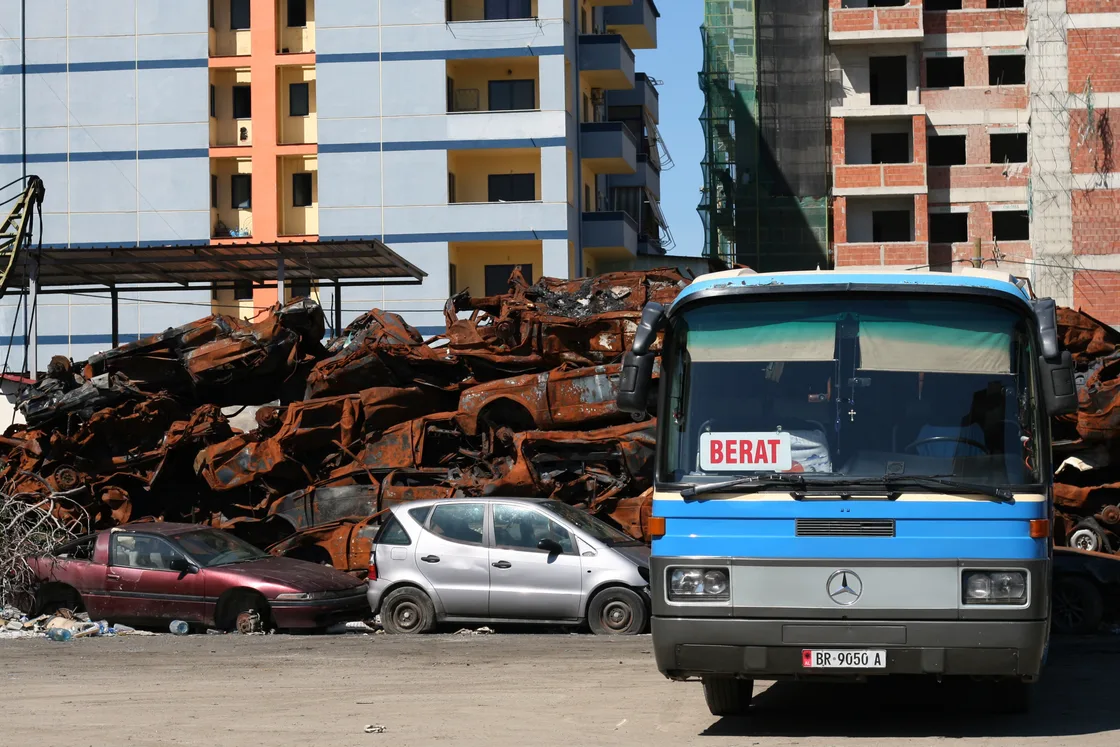 Buses and waiting passengers at an intercity bus terminal in Tirana