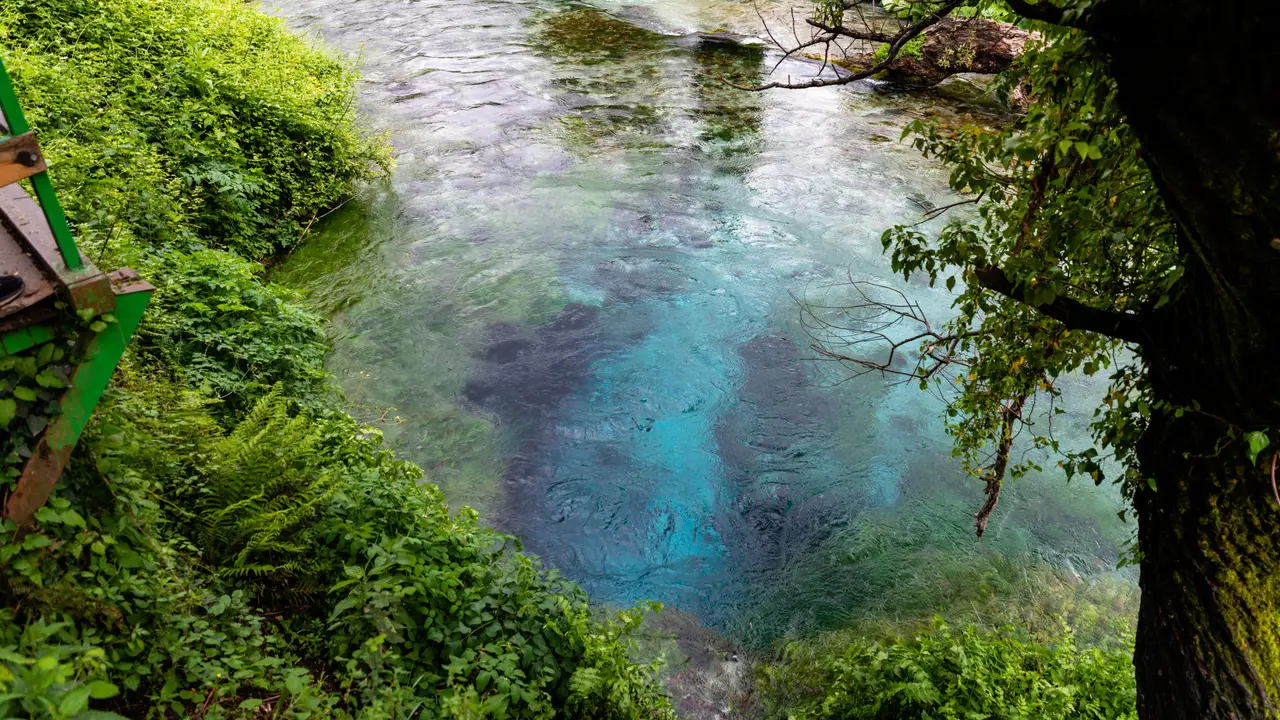 The deep blue water of the Blue Eye karst spring near Saranda, ringed by forest