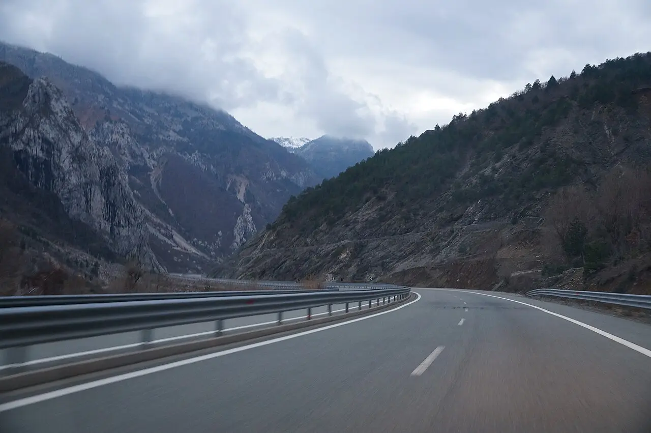 The A1 motorway curving through the forested Mirdita mountains under a cloudy sky