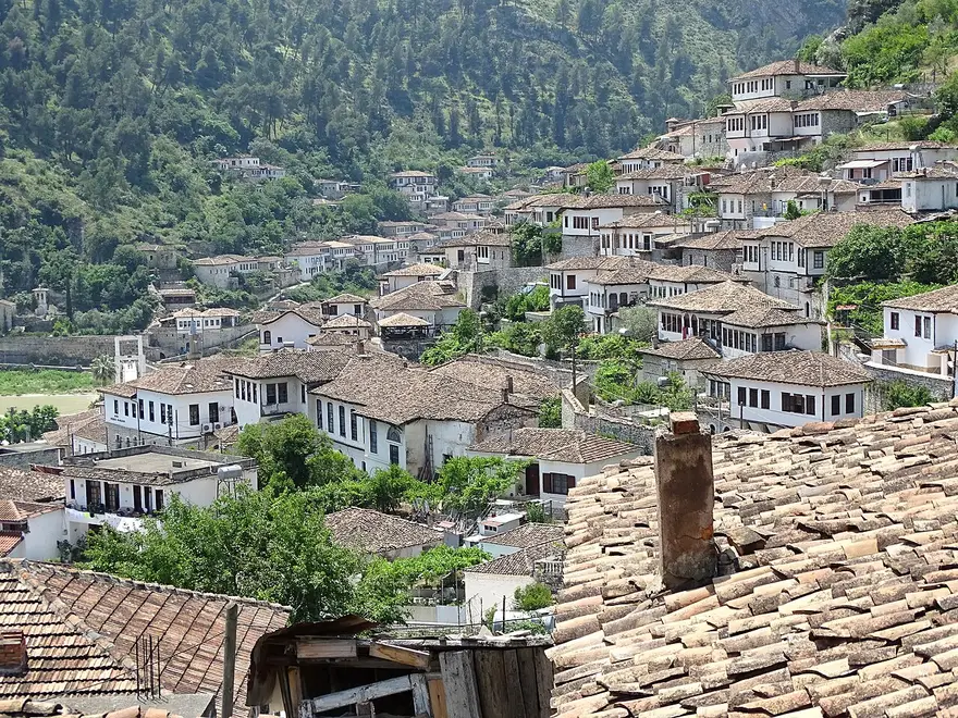 White Ottoman houses with wooden windows climbing the wooded hillside of the Mangalem quarter in Berat