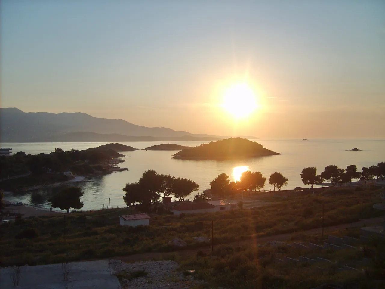 The small offshore islands of Ksamil at sunset, with the bay and beach in the foreground