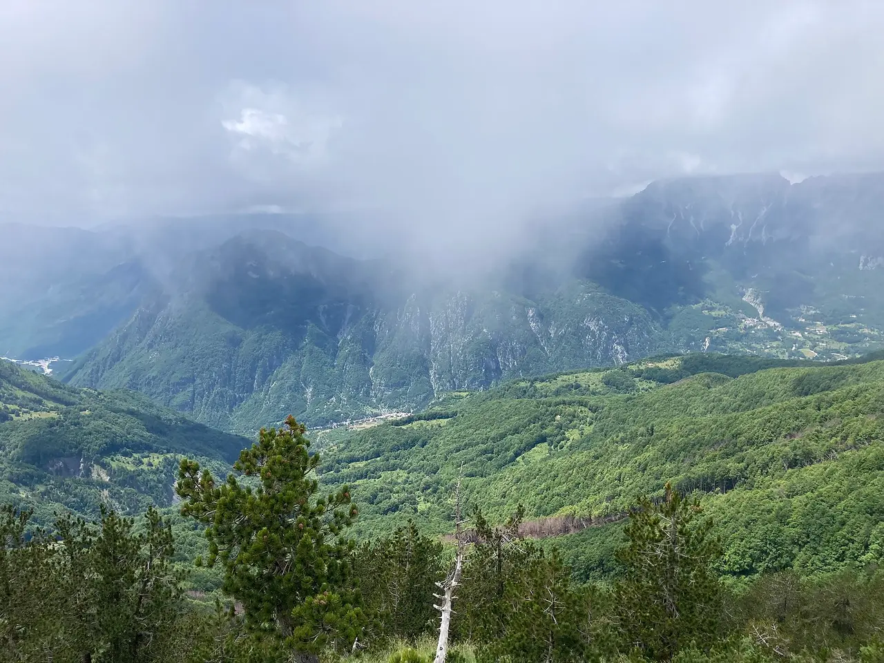 Cloud sinking over the forested ridges of the Valbona to Theth pass in the Albanian Alps