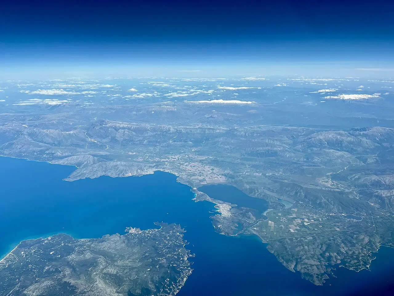 An aerial view of the Albanian coast, with cliffs meeting the clear Ionian Sea