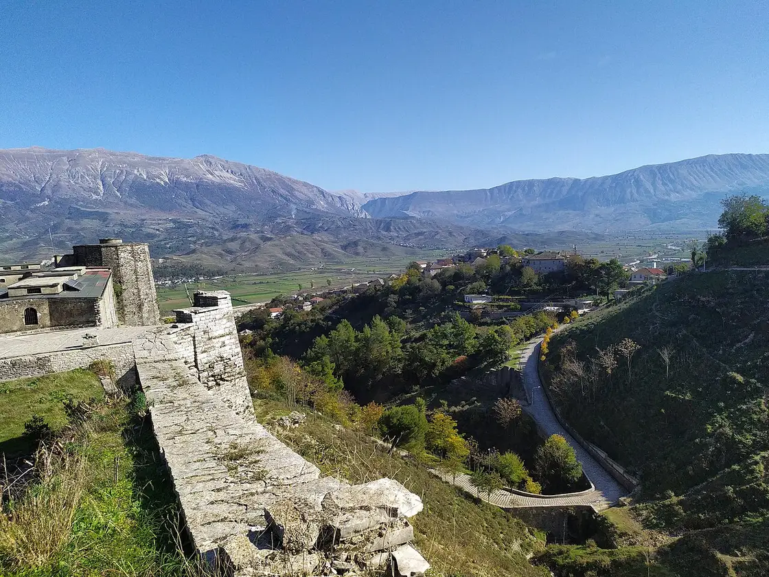 Stone rooftops of Gjirokaster Castle with the Drino valley and mountains beyond