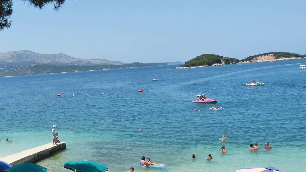 The shallow turquoise coves and small offshore islets of Ksamil in southern Albania on a calm summer day