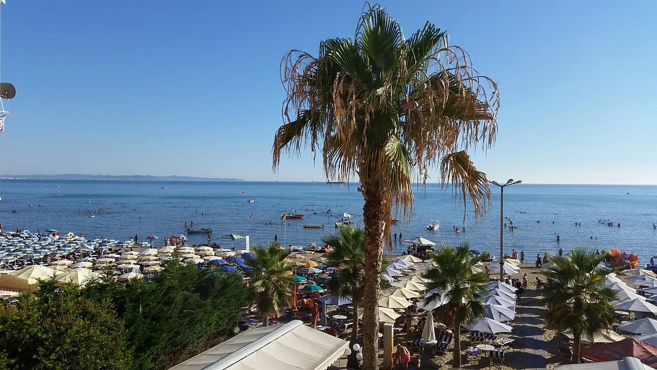 The long sandy beach of Durres with calm shallow water and hotels behind