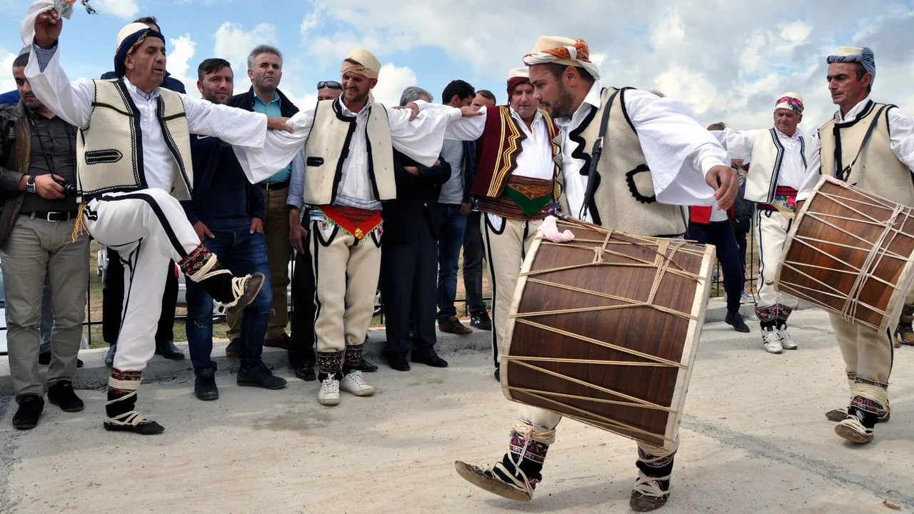Men in Gorani folk dress dancing to double-headed drums at Shishtavec in north-east Albania