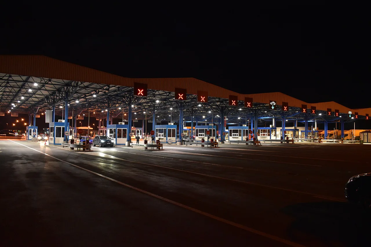 Border crossing lanes at Batrovci between Serbia and Croatia in the evening, with lit control booths