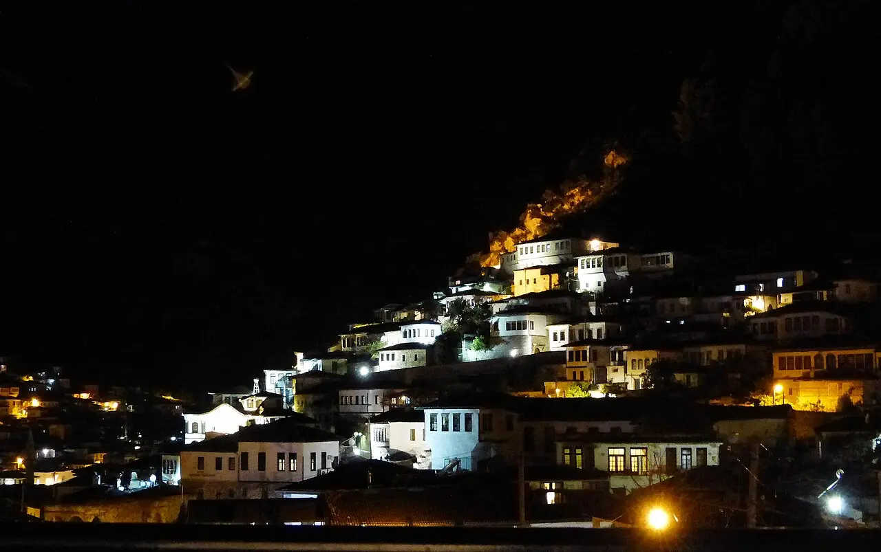 The lit windows of the Mangalem houses climbing the hillside in Berat after dark