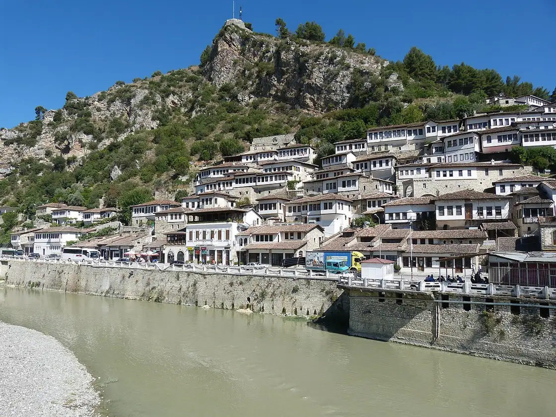 The white Ottoman houses of Mangalem rising up the hillside in Berat with the castle hill above