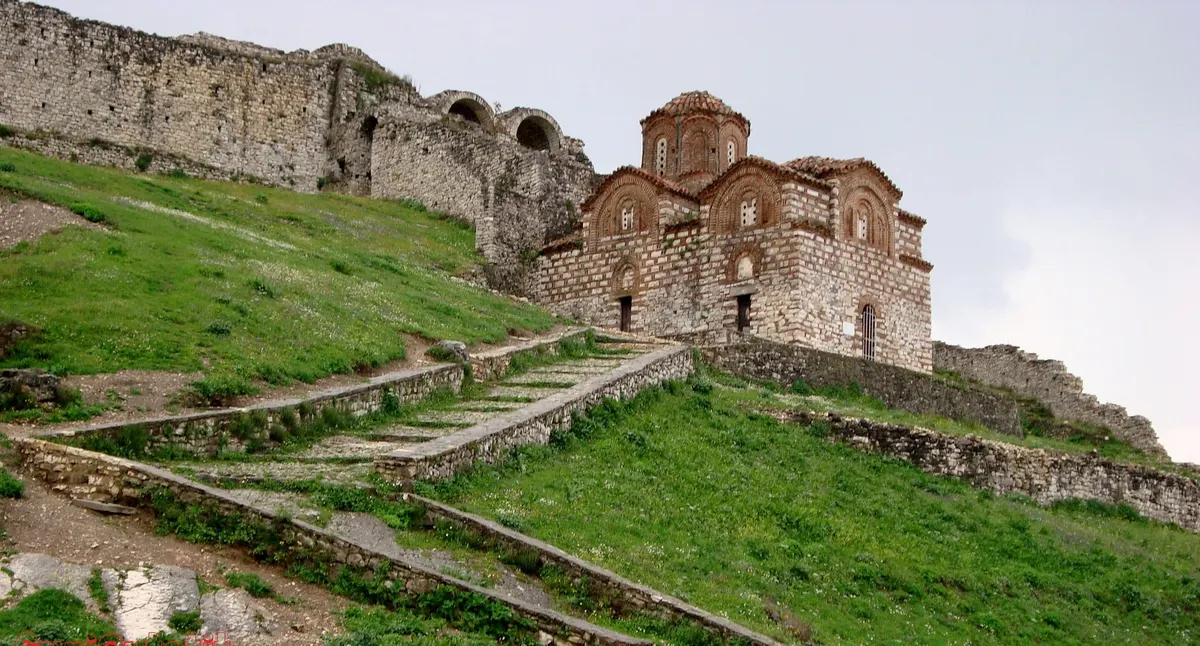 A small Byzantine brick church with a domed roof on the slope inside the Berat Castle walls