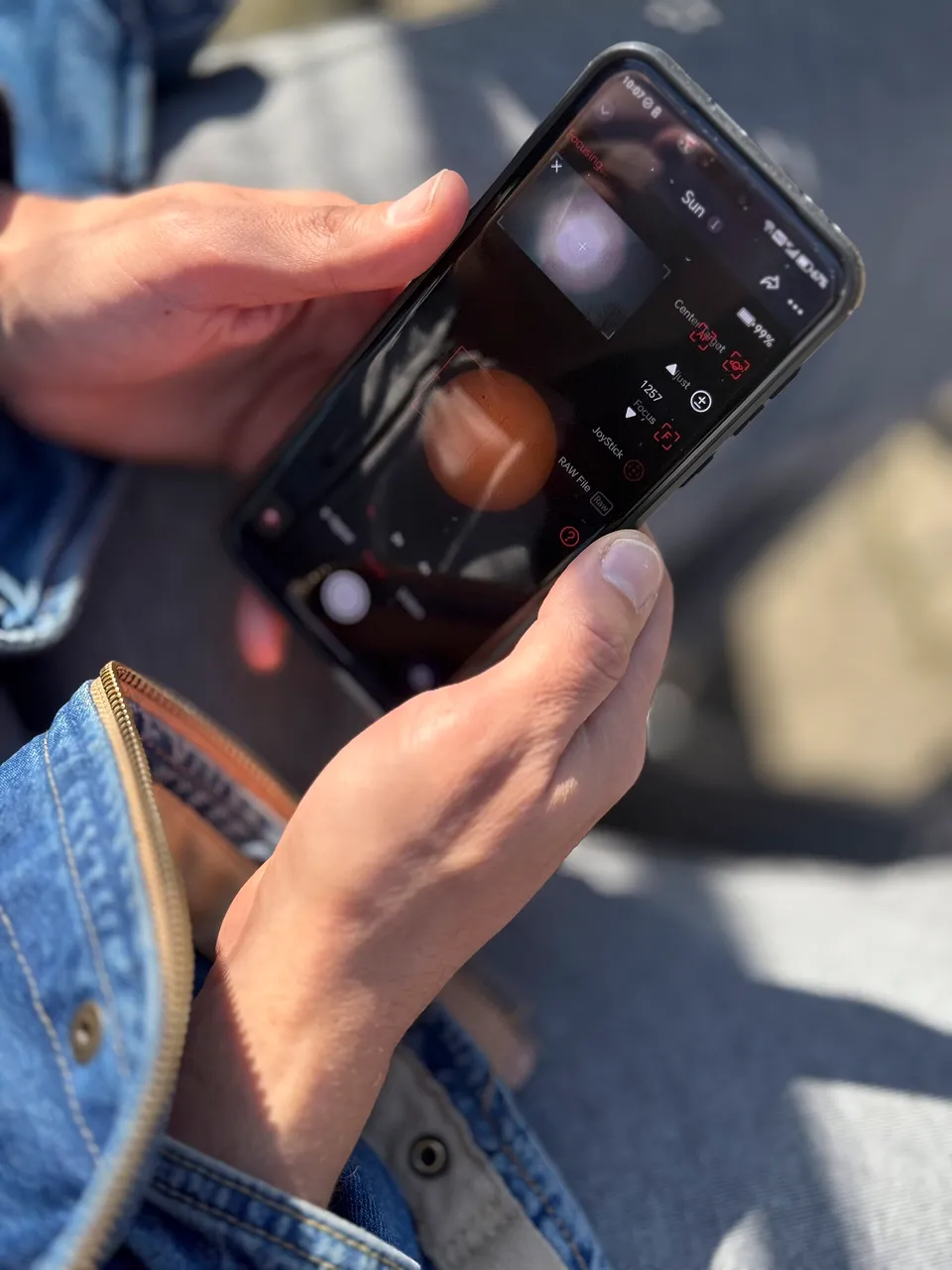 A traveller using a smartphone outdoors in the sun