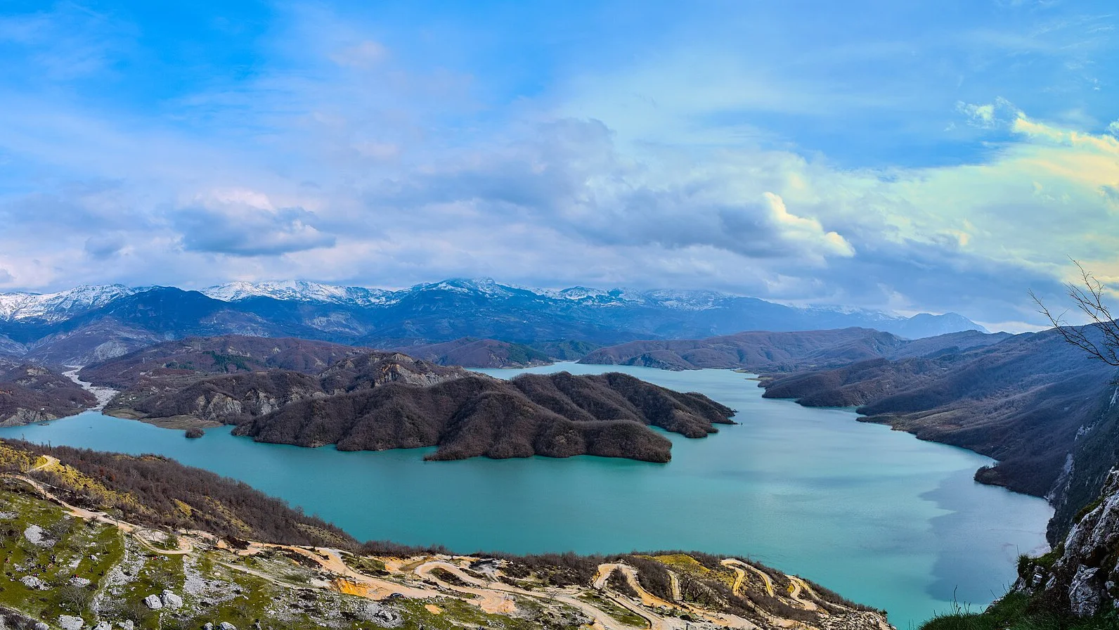 Turquoise Bovilla Reservoir winding between forested ridges in Dajti National Park