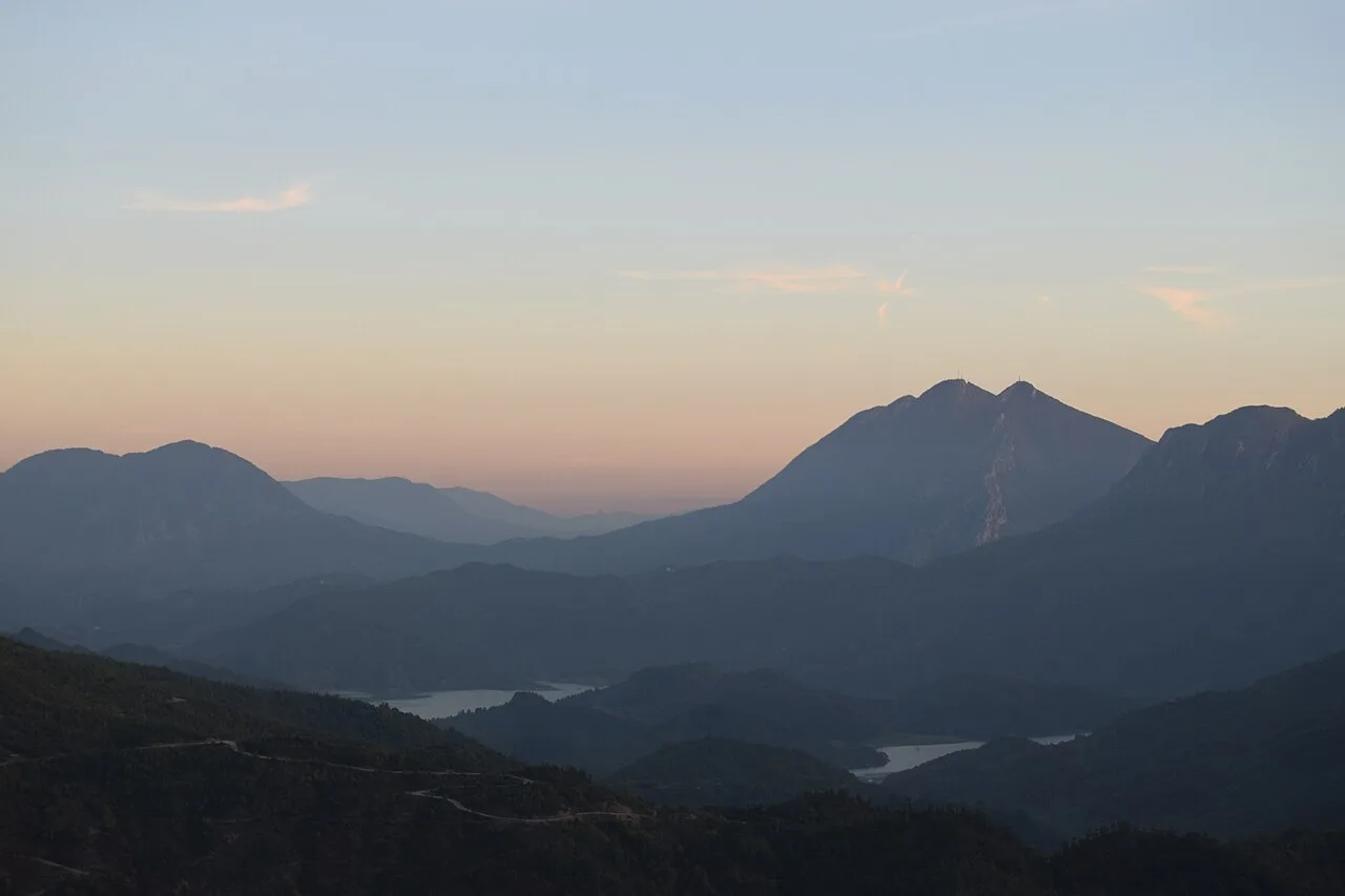 Wide turquoise stretch of Bovilla Lake with hills rising on both shores