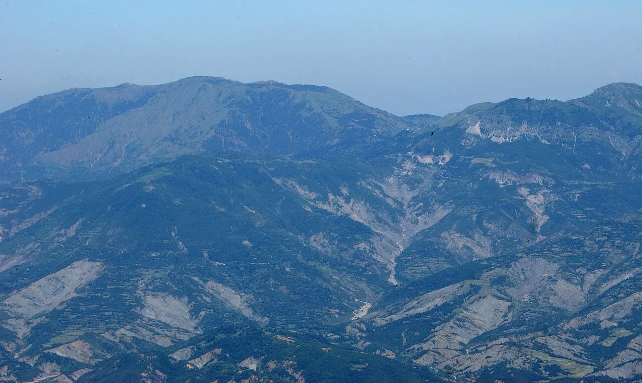 Rocky ridge above Bovilla country with sparse trees and open sky