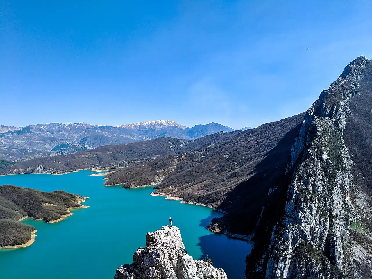 Bovilla Lake shoreline with turquoise water and steep vegetated slopes