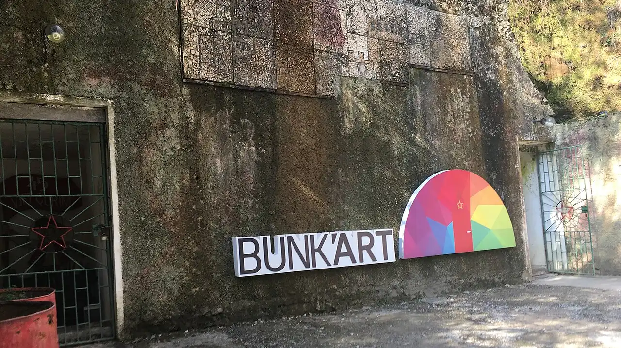 The concrete entrance wall of Bunk'Art 1 in Tirana with the museum name and bunker logo