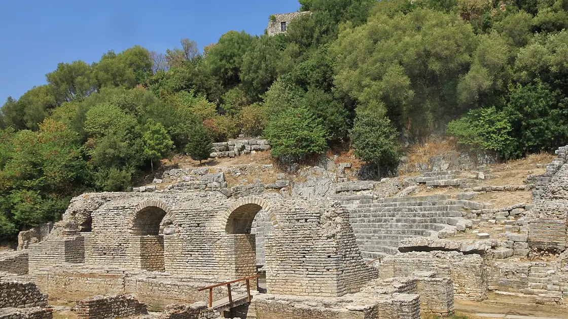 The ancient theatre and the hilltop fortress at Butrint among green wooded slopes