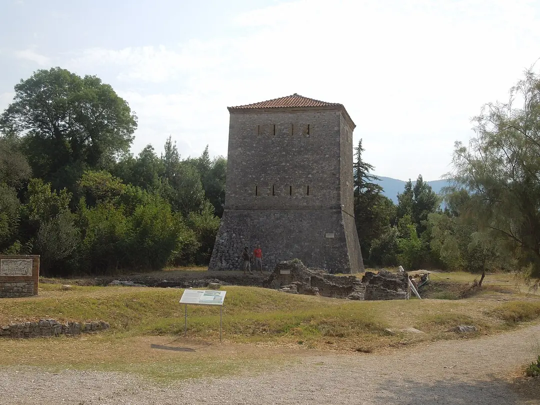 The square stone Venetian tower at Butrint with a tiled roof, beside the lagoon
