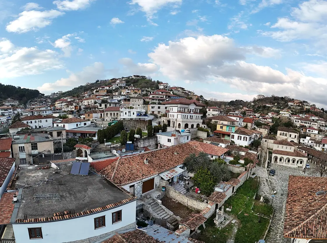 Aerial view over Berat old town with whitewashed houses on a wooded hillside