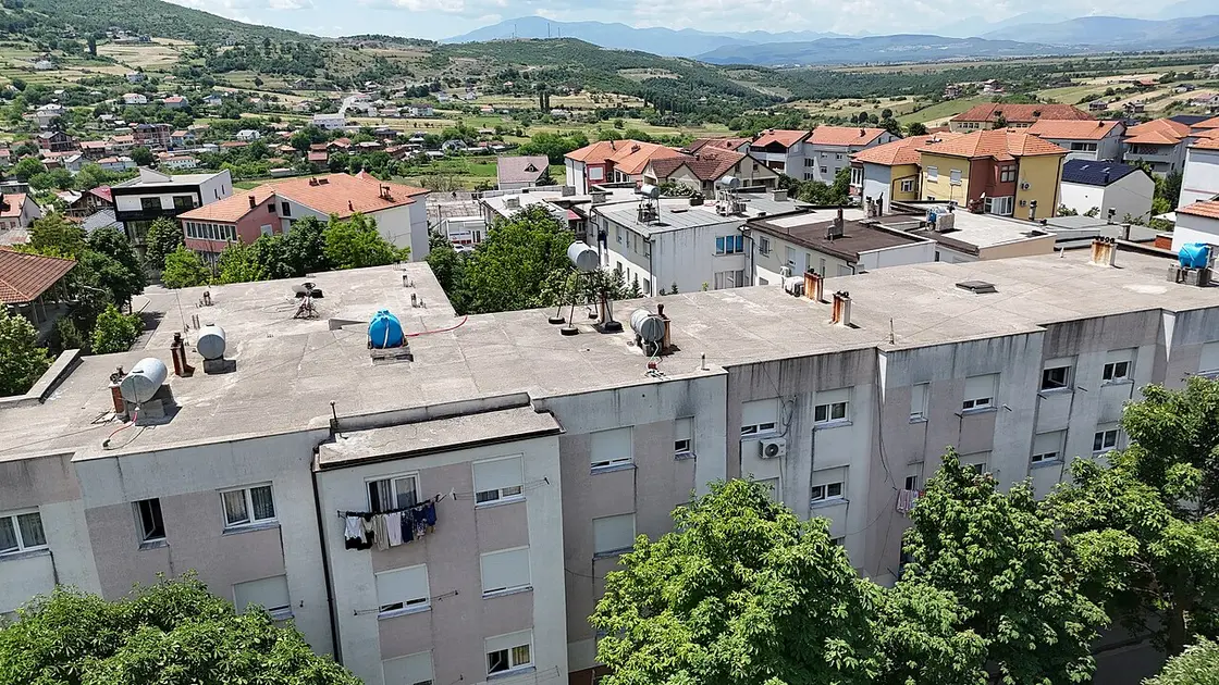 Aerial view of a small Albanian village with scattered houses and green fields