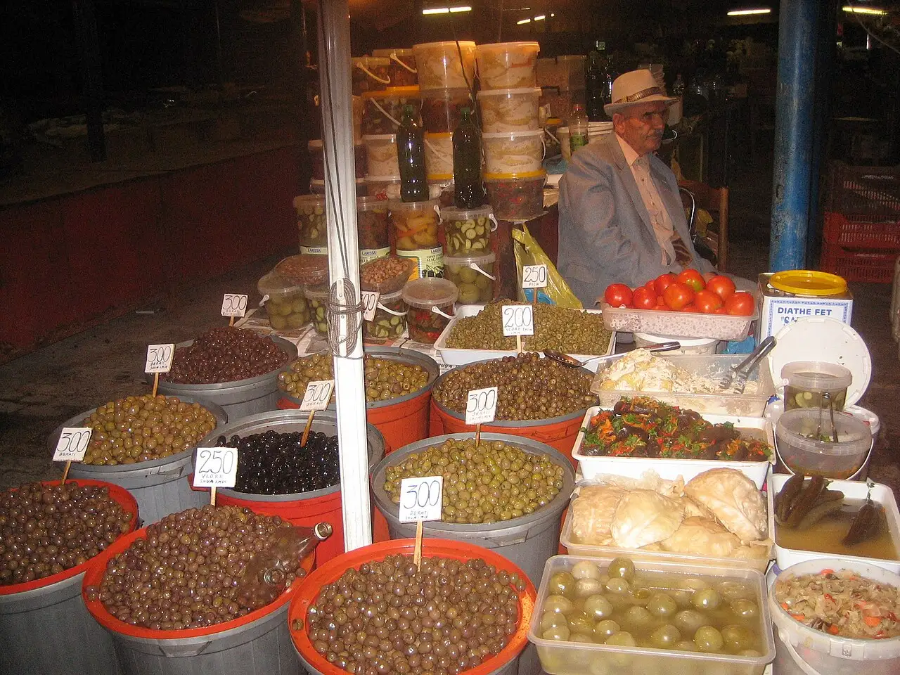An olive and pickle stall with large tubs at the Avni Rustemi market in Tirana
