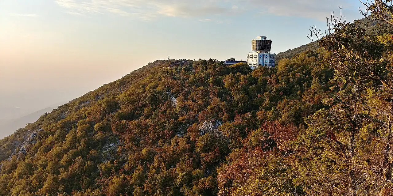 The Dajti Tower Belvedere hotel standing on the wooded ridge of Mount Dajti at sunset