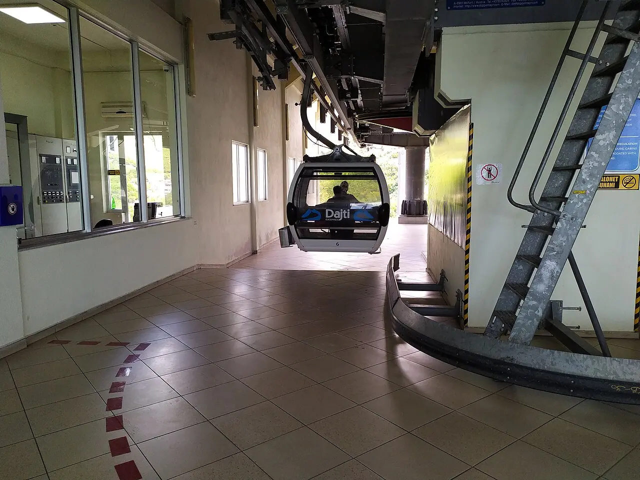A Dajti Ekspres gondola moving through the machinery of the cable-car station