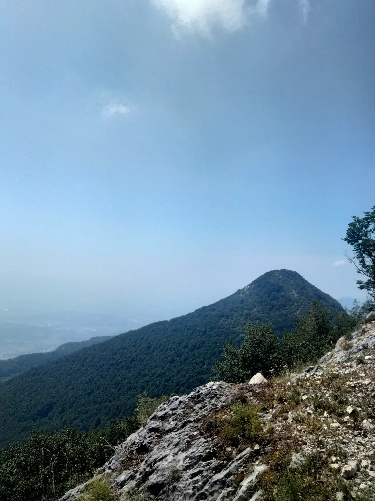 The wooded cone of Maja e Tujanit seen from the rocky ridge trail on Mount Dajti