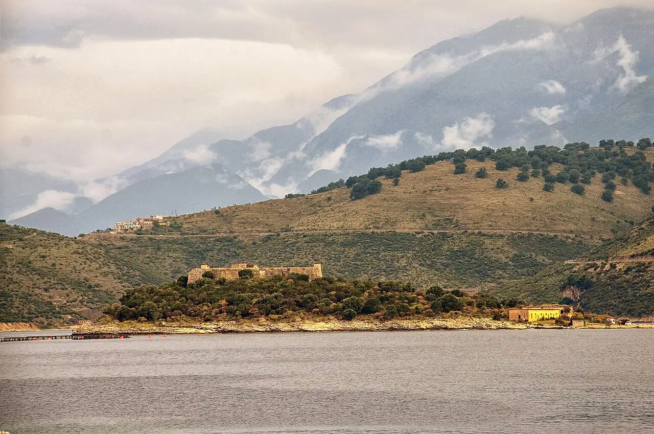 Porto Palermo castle on its wooded peninsula in a calm bay below the Ceraunian mountains