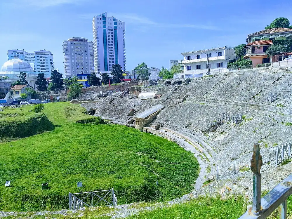 The Roman amphitheatre of Durres with the modern city and apartment towers rising behind it
