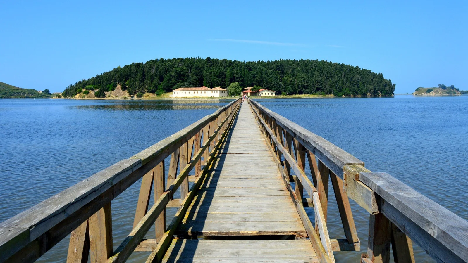 The wooden footbridge across the Narta lagoon to the pine-covered island and the monastery buildings at Zvernec near Vlora
