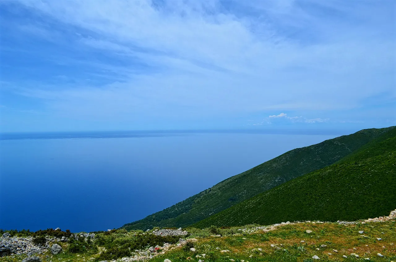 The green mountainside and switchback road near the top of the Llogara Pass above the Ionian coast