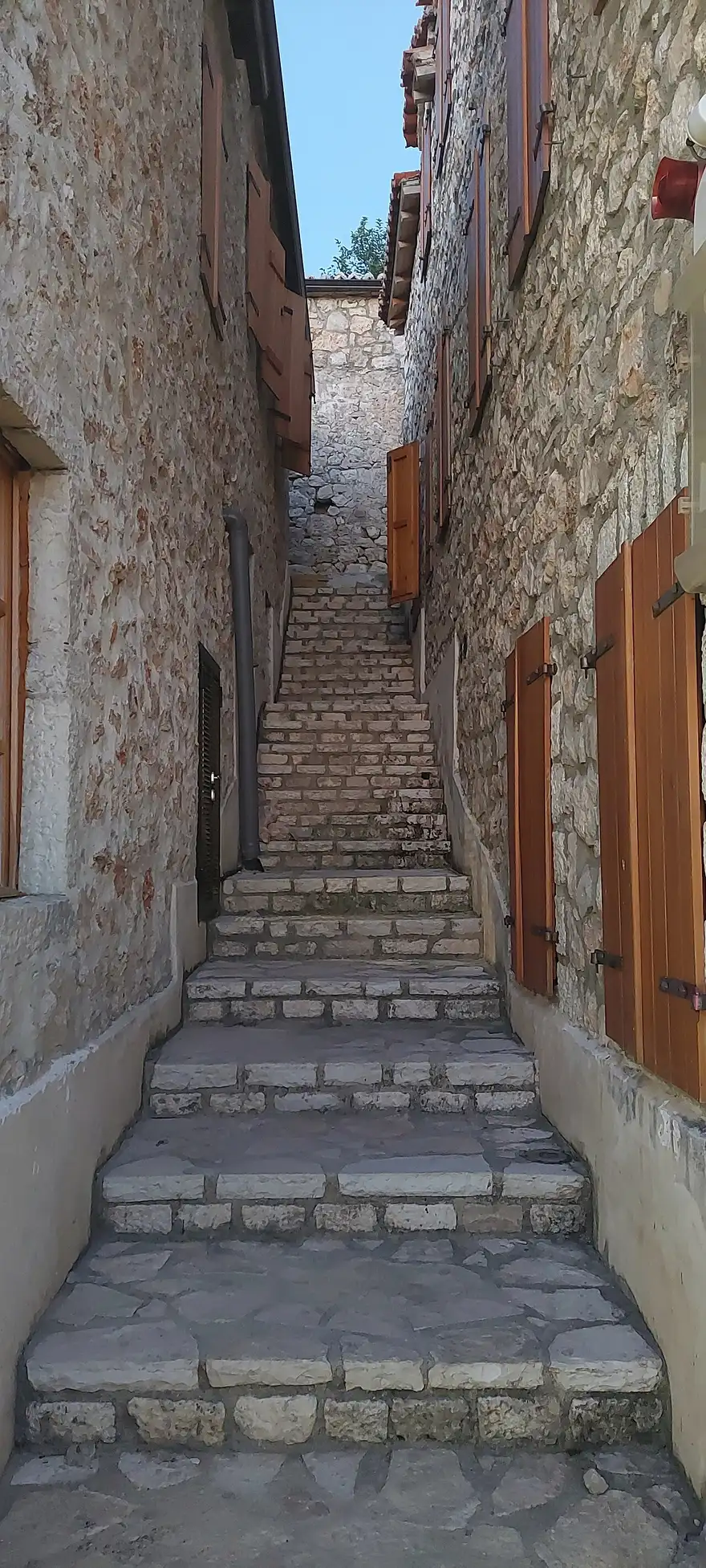 A narrow stone-paved alley between old houses in the upper village of Dhermi