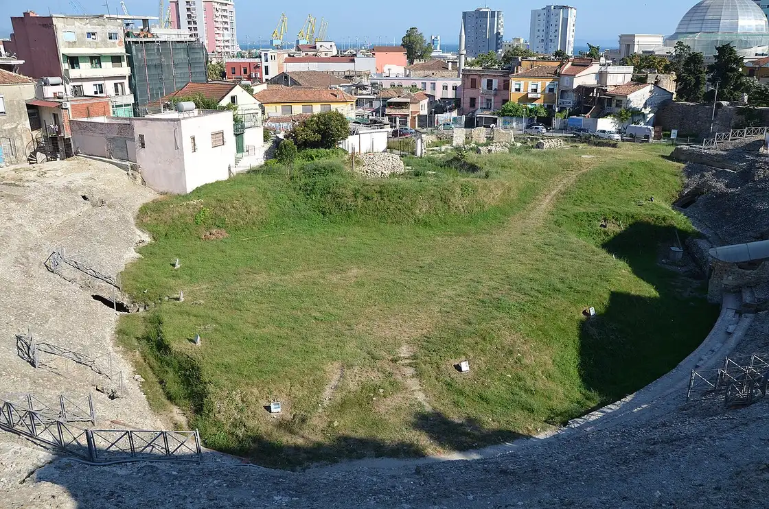 The arena floor and curved stone seating tiers of the Roman amphitheatre of Durrës