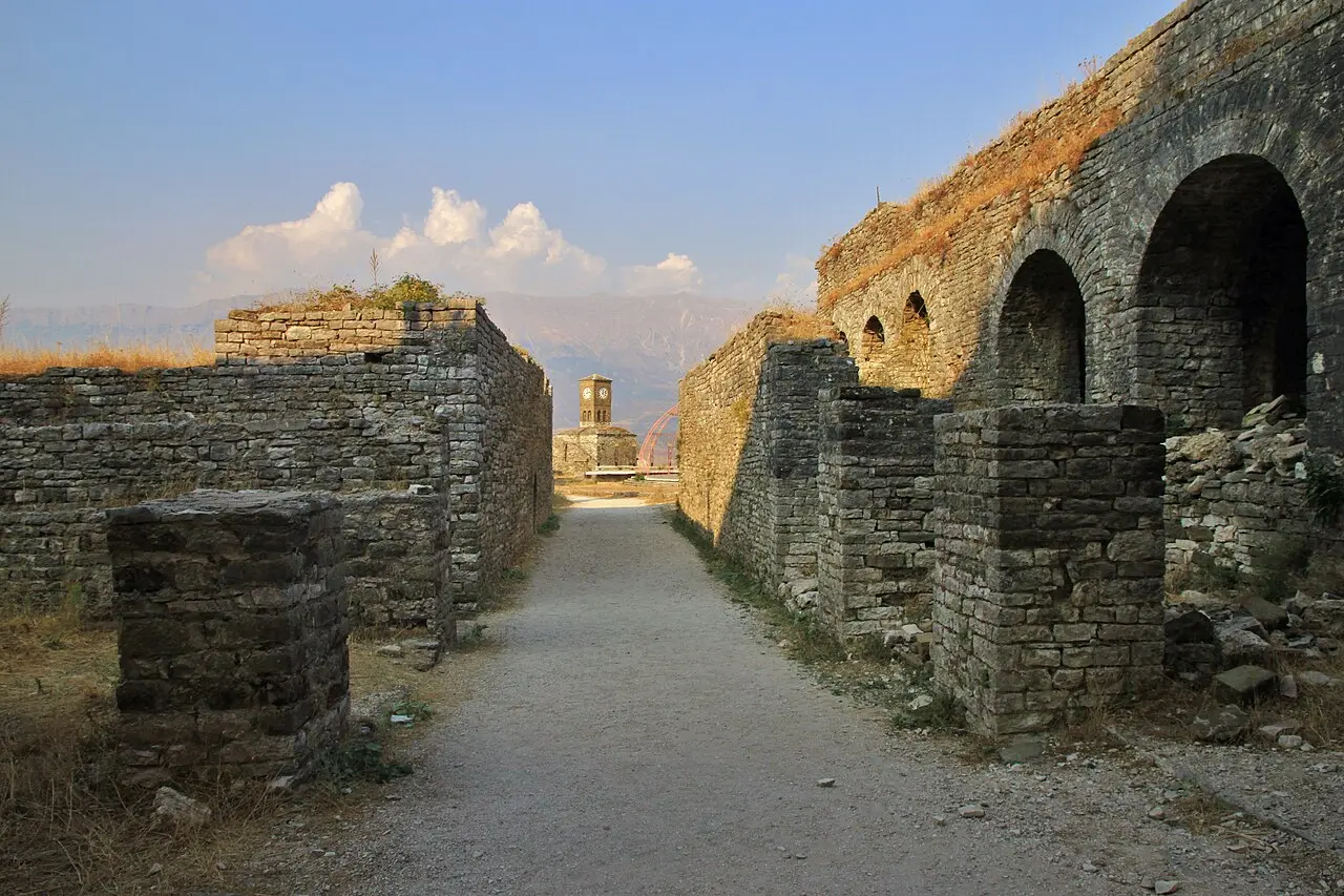 The long stone vaulted gallery and ramparts inside Gjirokastër castle with the clock tower at the end