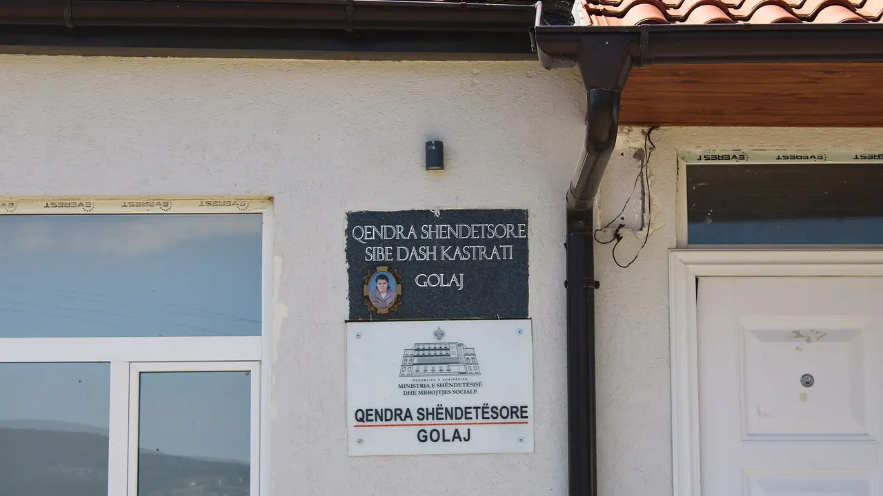 Exterior of a public health centre building in northern Albania with a red-cross sign above the entrance