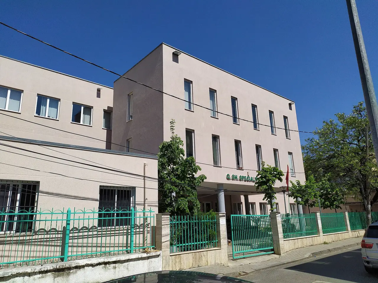 Entrance of Health Centre No. 1 in Tirana with a red cross and Albanian flag