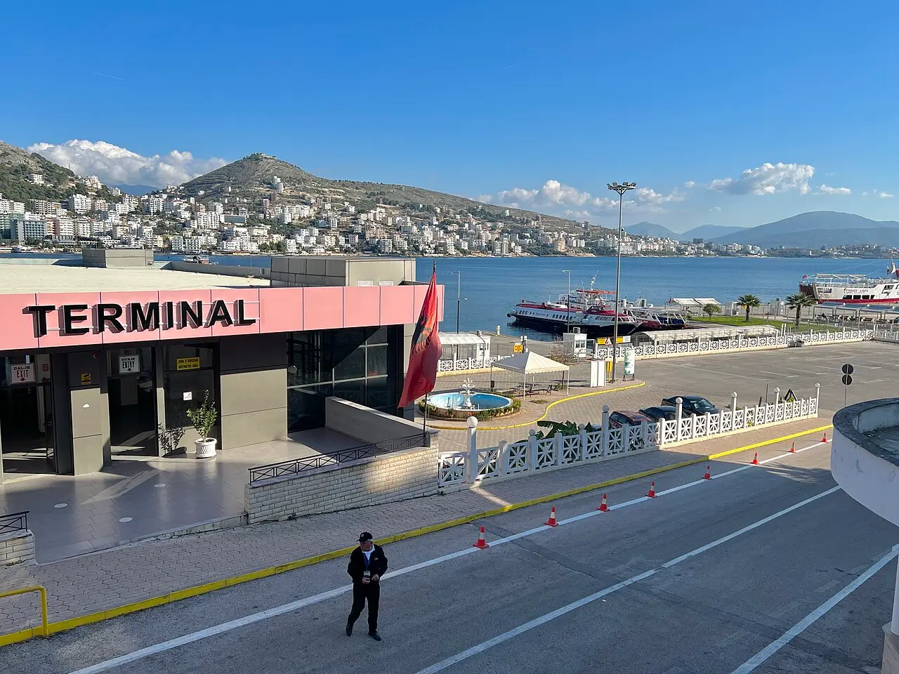 The passenger terminal building at Saranda on the waterfront, with the bay and hills behind