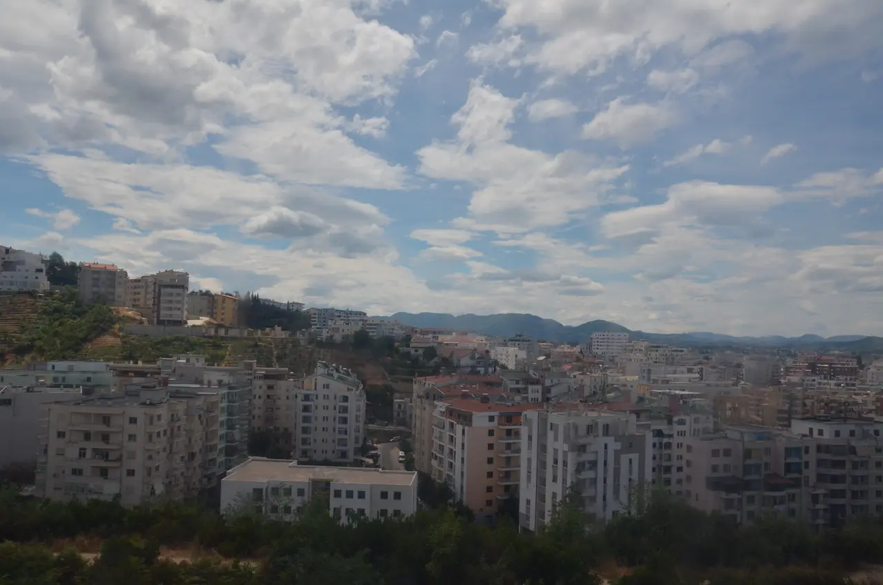 The skyline of central Tirana, the Albanian capital, with apartment blocks and hills behind