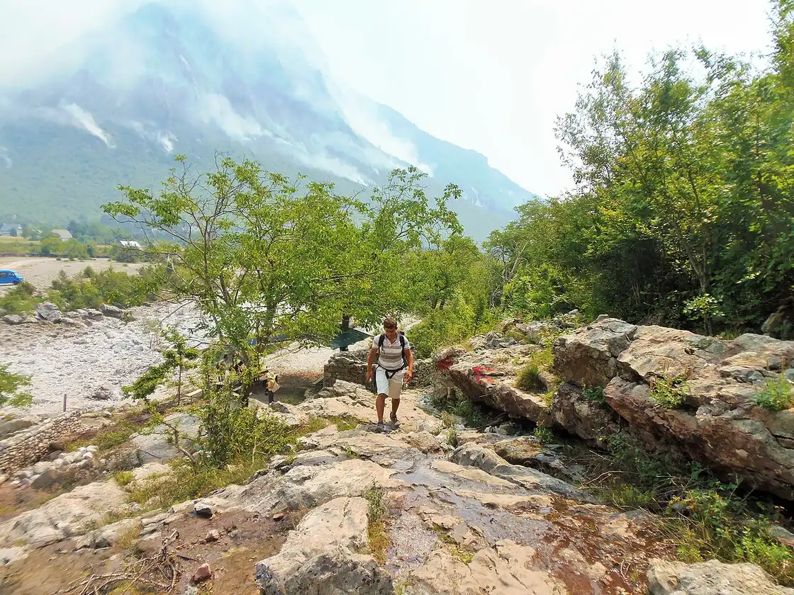 Stone houses of Theth village scattered below the peaks of the Albanian Alps