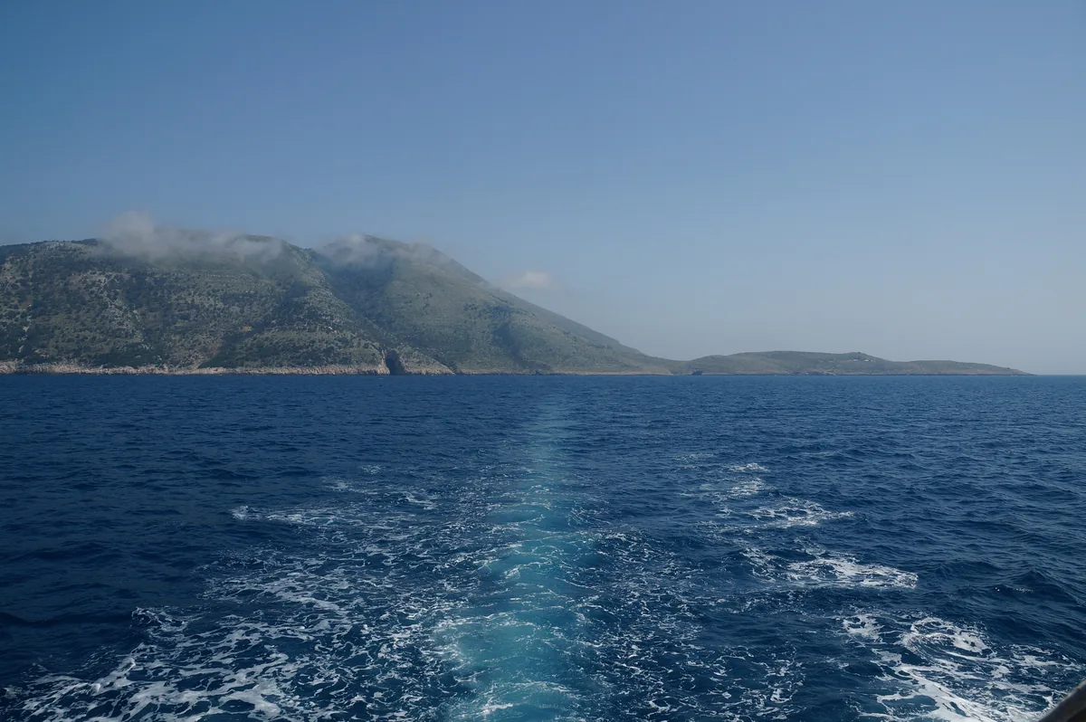The green headland of Cape Gjuhez at the tip of the Karaburun peninsula seen from a departing boat