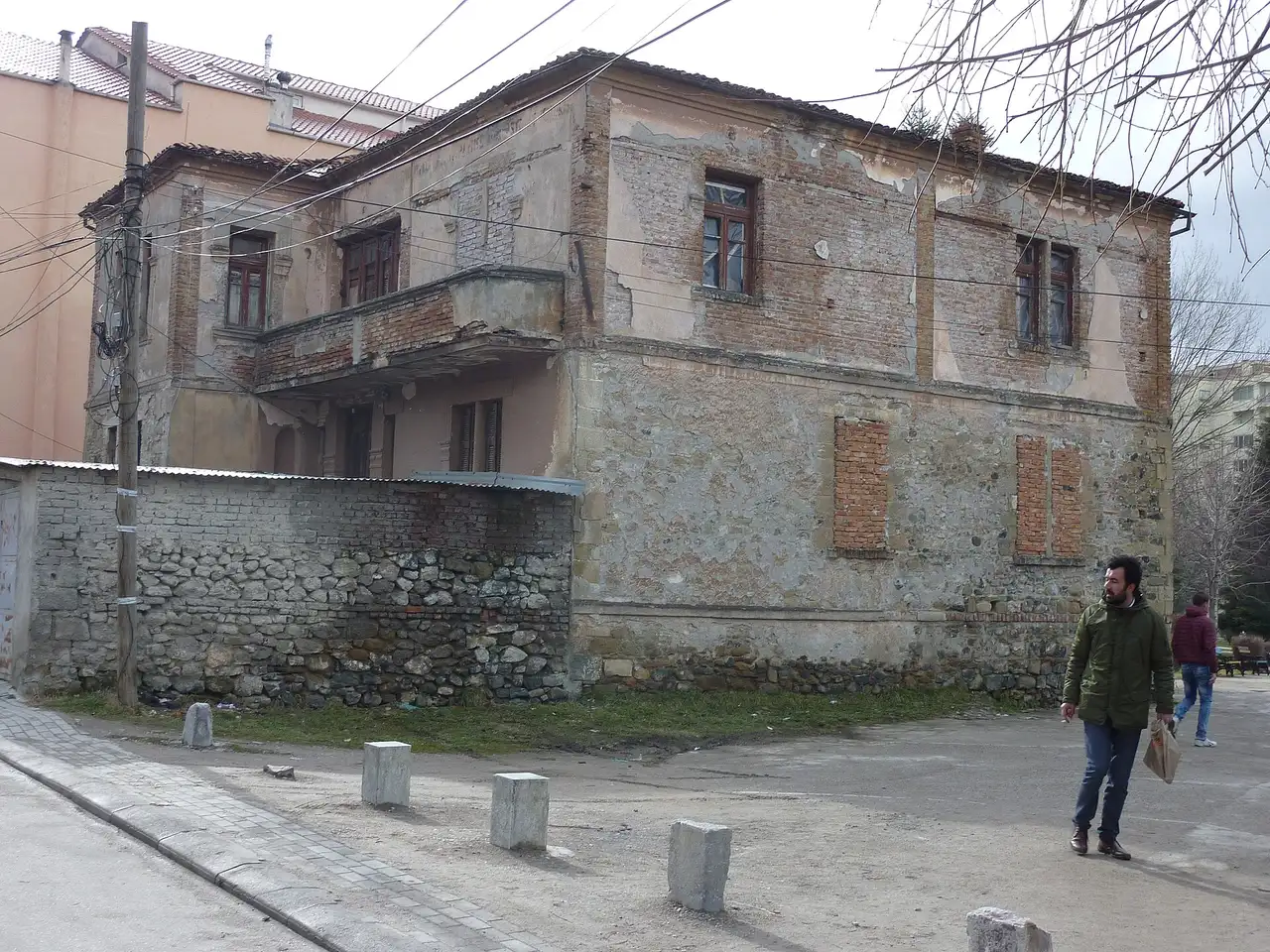A restored traditional stone-and-wood house facade in Korça