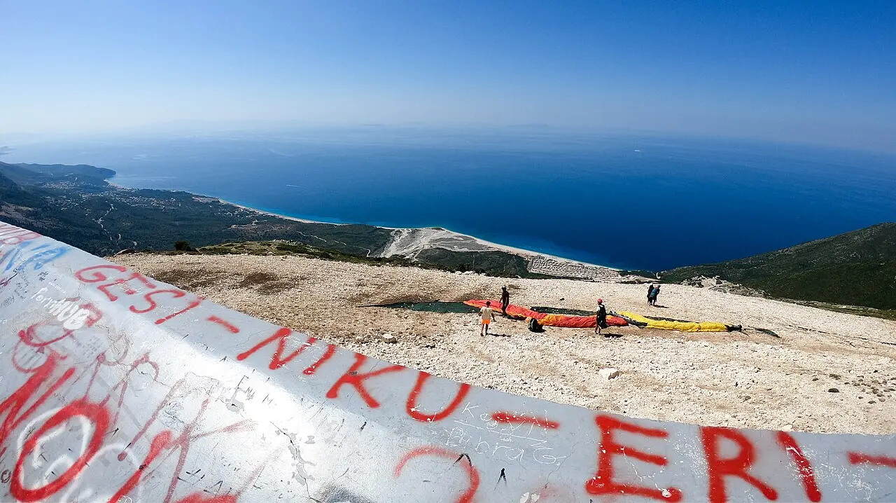 The deep blue Ionian and the long white spit of Palasa beach seen from the Llogara paragliding launch high above the coast