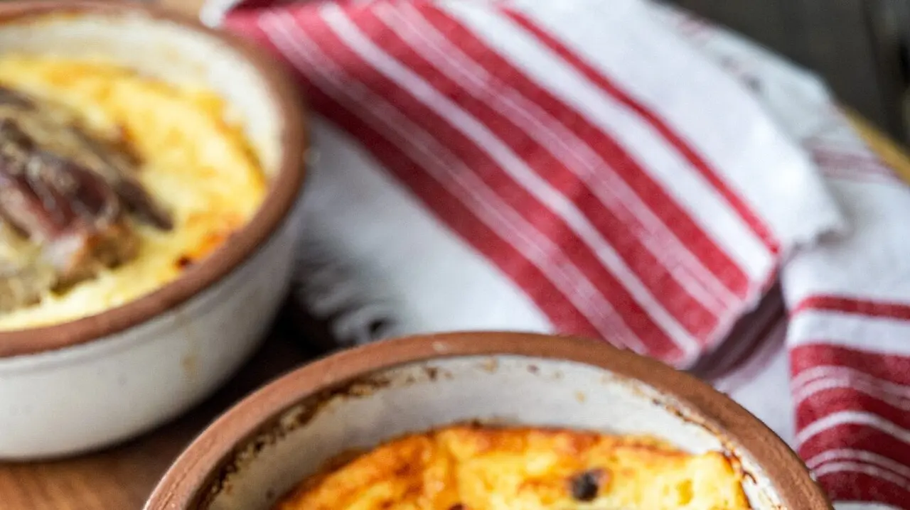 Tavë kosi, a baked Albanian dish of lamb and yoghurt, in earthenware bowls